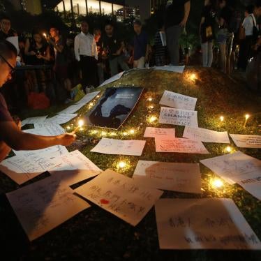People light candles next to signs at a vigil in solidarity with protesters of the "Occupy Central" movement in Hong Kong, at Speakers' Corner in Hong Lim Park, Singapore, on October 1, 2014.