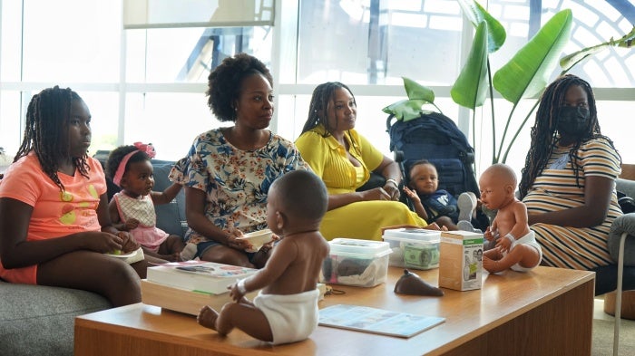 A group of women and children seated at a workshop