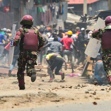 Armed riot police officers run towards protesters