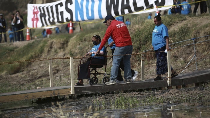 People living in Mexico cross a temporary bridge to meet with relatives living in the U.S., during the 10th annual "Hugs not Walls" event on a stretch of the Rio Grande, in Ciudad Juarez, Mexico, Saturday, May 6, 2023. The brief family reunions are part of a campaign sponsored by the Border Network for Human Rights, an immigration rights group. © 2023 AP Photo/Christian Chavez